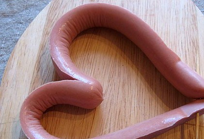 1. Этап. Яичница в сосиске сердечком: Теперь сводим концы сосиски так, чтобы у нас получилось сердечко, скрепляем кончики зубочисткой.