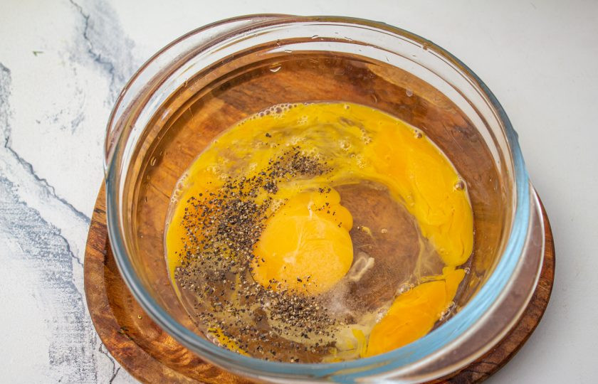 1. Этап. Заливной пирог с капустой и сыром: В подходящую емкость вбейте куриные яйца, добавьте соль и черный молотый перец.