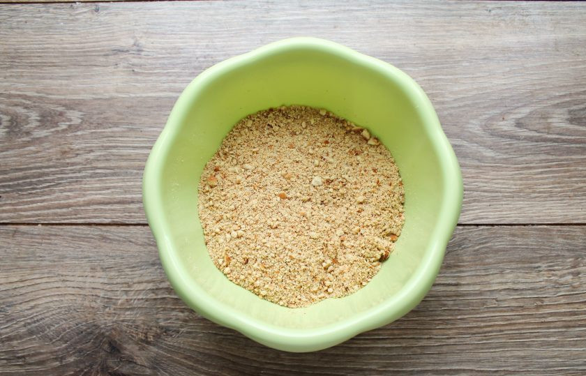 1. Этап. Корж из печенья без выпечки: Измельчите печенье в крошку любым удобным способом и выложите в миску. Влейте в крошку желатин и хорошо перетрите руками до равномерного распределения.