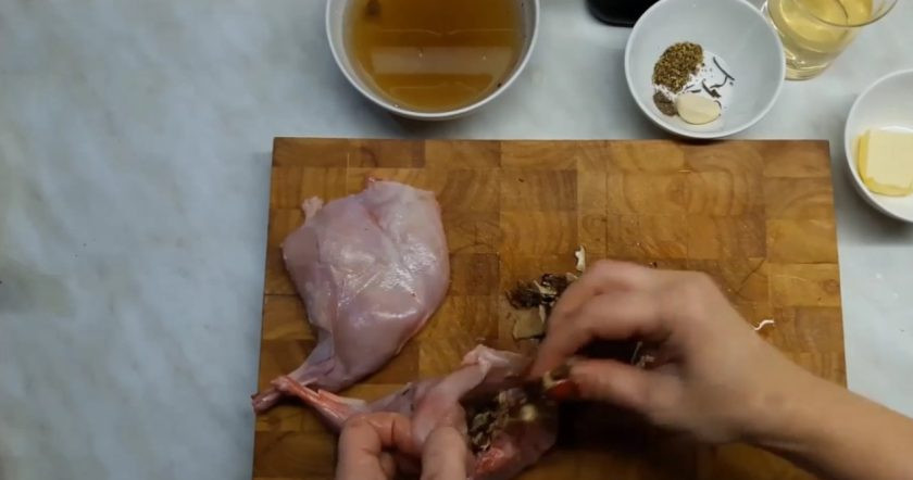 1. Этап. Кролик, фаршированный грибами: 2. Подготовьте начинку. Нарежьте в произвольном порядке грибы, посолите и добавьте розмарин. Нафаршируйте грибами ножки, добавьте немного сливочного масла в мясо. Далее заверните мясо и придайте ему форму, слегка обмотайте его сверху ниткой, чтобы при жарке ножка сохранила красивую форму.