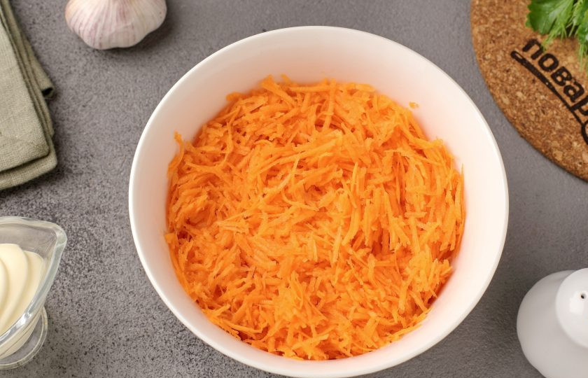 1. Этап. Салат из морковки с чесноком и майонезом: Морковь промойте, очистите и натрите на мелкой тёрке.