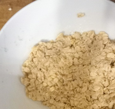 1. Этап. Крамбл из ревеня: Делаем засыпку, смешав натертое масло, соль, овсяные хлопья и миндаль. Тщательно перемешиваем. Выкладываем топпинг на начинку. Отправляем ёмкость для запекания в морозилку на 10 минут или в холодильник от 30 минут до 48 часов.