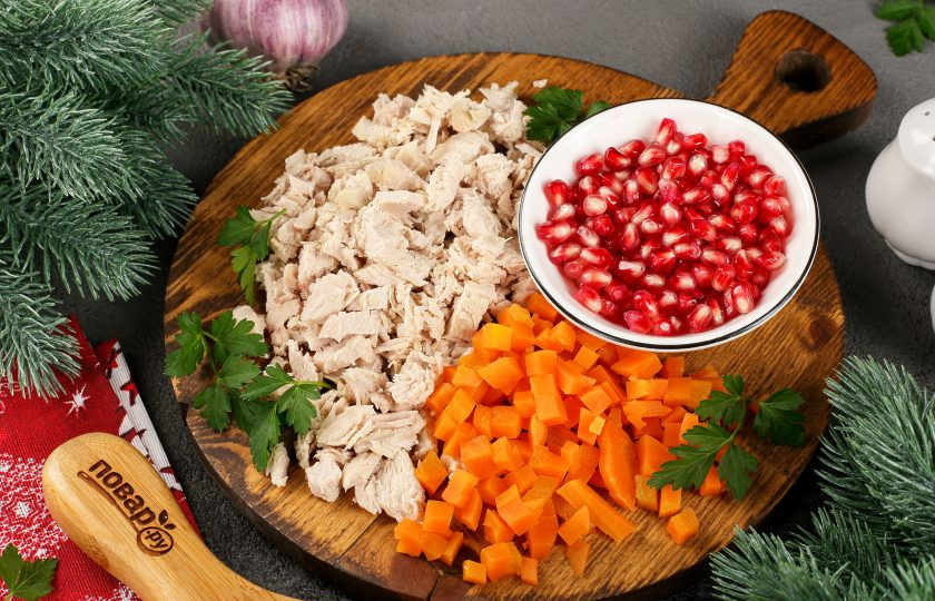 1. Этап. Заливные Драконьи яйца на Новый год 2024: Куриную грудку и морковь нарежьте кубиками. Подготовьте листики петрушки по количеству яиц и зёрна граната.