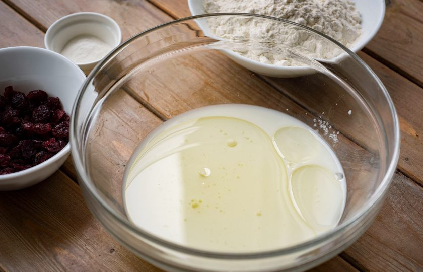 1. Этап. Вафли с клюквой: В просторную миску залейте молоко, добавьте растительное масло, сахар. Перемешайте.