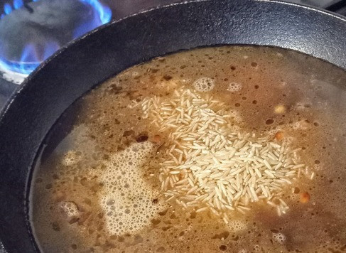 1. Этап. Фруктово-ореховый пилав с соусом тахини: Добавить рис, соль и перец. Жарить буквально одну минуту. Затем добавить курагу, изюм и влить воду.