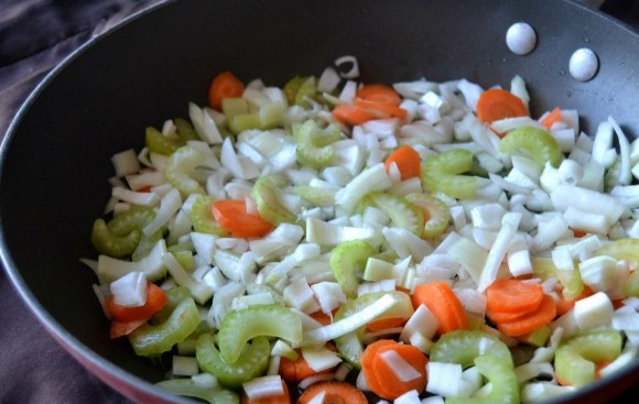 1. Этап. Картофельный суп с молоком: 5. Нарезанные овощи (лук, сельдерей и морковь) выложите на сковородку с небольшим количеством масла. Долейте немного воды. Накройте крышкой. Тушите овощи до готовности.