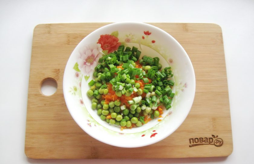 1. Этап. Салат с зеленым горошком и морковью: Зеленый лук помойте и мелко нарежьте. Выложите в салатник с другими ингредиентами.