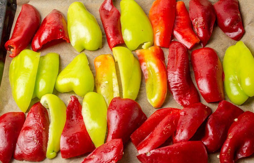 1. Этап. Перец с базиликом на зиму: Противень для запекания застелите пекарской бумагой. Выложите перцы шкуркой вверх в один ряд на небольшом расстоянии друг от друга. Отправьте противень в разогретую духовку, и запекайте перцы при температуре 180-200 градусов на 20-30 минут. Время запекания зависит от возможностей вашей духовки.