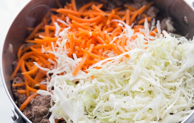 1. Этап. Тушенная капуста с фаршем: 1. Вначале мелко нашинкуйте лук, капусту и морковь. Потом обжарьте пару минут фарш с луком в масле в большой сковороде. Следом добавьте к ним капусту и морковь. Тушите ингредиенты 5 минут.