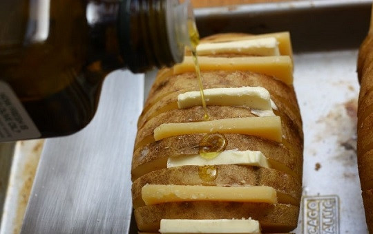 1. Этап. Картофельный веер с сыром: 5. Выложите картофель на противень. Поочередно помешайте в отверстия масло и сыр. Сверху полейте небольшим количеством оливкового масла.