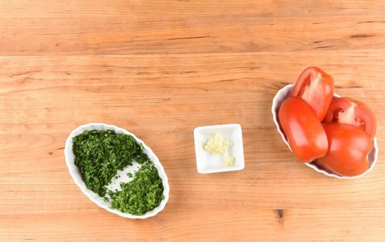 1. Этап. Чимичурри стейк: 2. Помидоры разделите пополам. Чеснок и петрушку мелко нарубите.