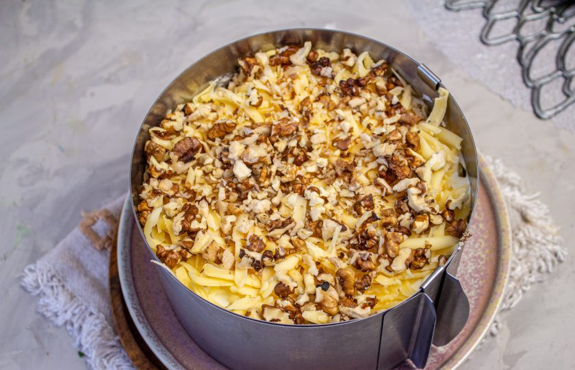 1. Этап. Салат с копченой курицей, черносливом и грецкими орехами: Грецкие орехи слегка подсушите в духовке или на сухой сковороде, затем мелко порубите. Посыпьте орехи на сыр. Уберите салат в холодильник на пару часов для стабилизации.