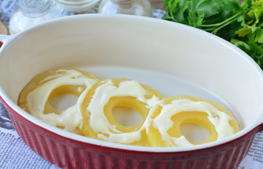 1. Этап. Ананасы под сыром в духовке: Смажьте ананасы майонезом.