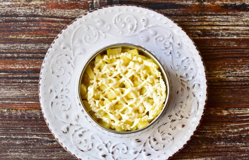 1. Этап. Оливье с ананасом: Затем на огурцы выложите вареный картофель, который нарежьте кубиками.