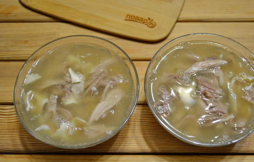 1. Этап. Холодец из свинины и говядины: 8. В теплый бульон добавьте пропущенный через пресс чеснок, перемешивайте. Проверьте, чтобы в бульоне не было косточек, можно процедить бульон через марлю. Залейте бульоном все тарелочки. На первых тарелочкам больше жира вышло сверху, на последних (на фото) бульон менее жирный. Отправьте тарелочки в холодцом в холодильник на ночь.