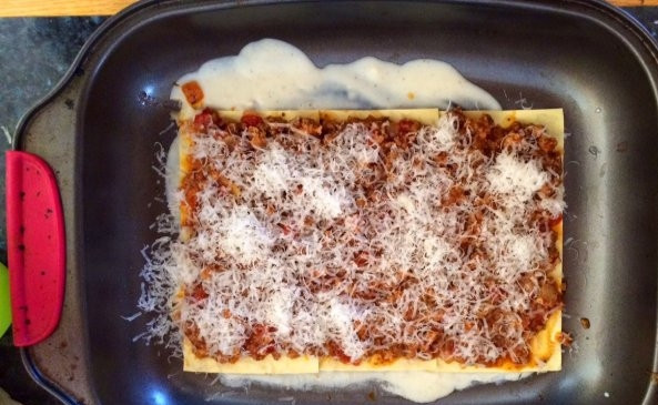 1. Этап. Итальянская лазанья: Духовку разогрейте до 200 градусов. В форму налейте несколько столовых ложек бешамеля. Затем на дно выложите несколько листов теста для лазаньи. На тесто выложите мясную начинку, насыпьте немного пармезана, затем налейте несколько ложек бешамеля.