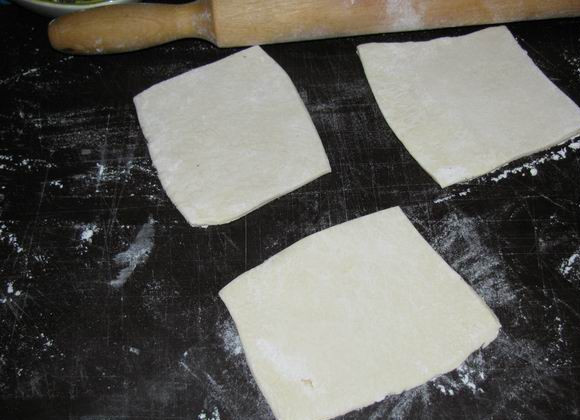 1. Этап. Пирожки с красной рыбой: 3. Размороженное слоеное тесто нарезать небольшими квадратами и слегка раскатать. Слишком тонкое тесто делать не стоит, чтобы пирожки были более воздушными.