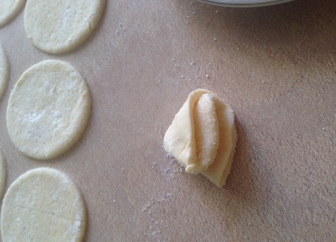 1. Этап. Печенье Гусиные лапки с творогом: Сахар насыпаем в блюдце . Макаем кружочек теста в сахар, складываем пополам, опять макаем в сахар и сложим вот такое печенье. Слегка прижимаем уголок печенья. Верхушку печенья тоже обмакнем в сахар.