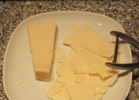 1. Этап. Салат с сыром Пармезан: Сыр с помощью овощечистки настрогаем тонкими ломтиками.