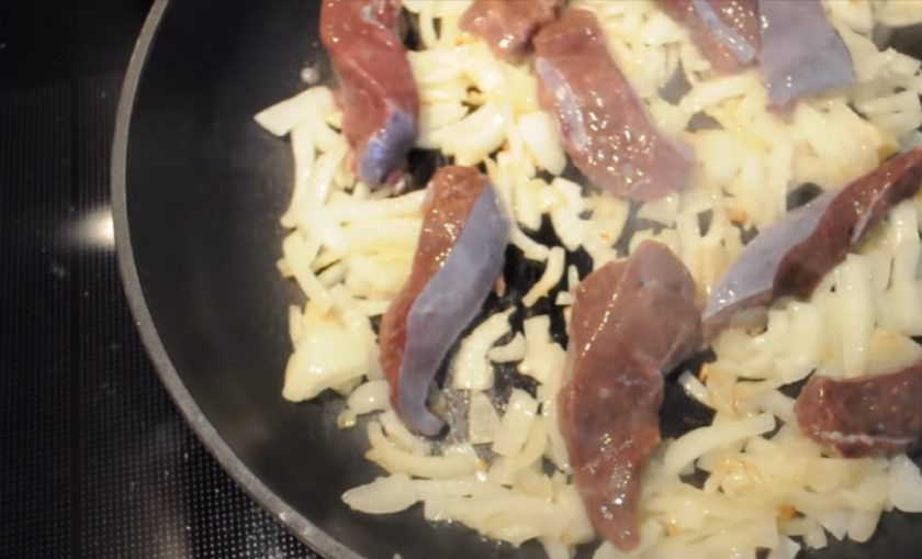 1. Этап. Печень, тушенная в сметане: 2. Нарежьте полукольцами лук, обжарьте его до золотистой корочки и добавьте к нему печень. Периодически переворачивая, обжарьте печень со всех сторон. Добавьте соль и перец.