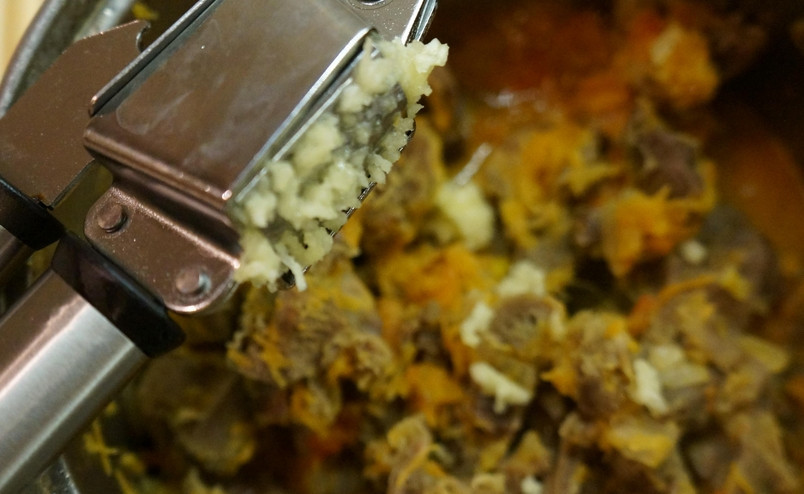 1. Этап. Тушеные куриные желудки: Чеснок пропускаем через пресс, добавляем в кастрюлю. Перемешиваем.