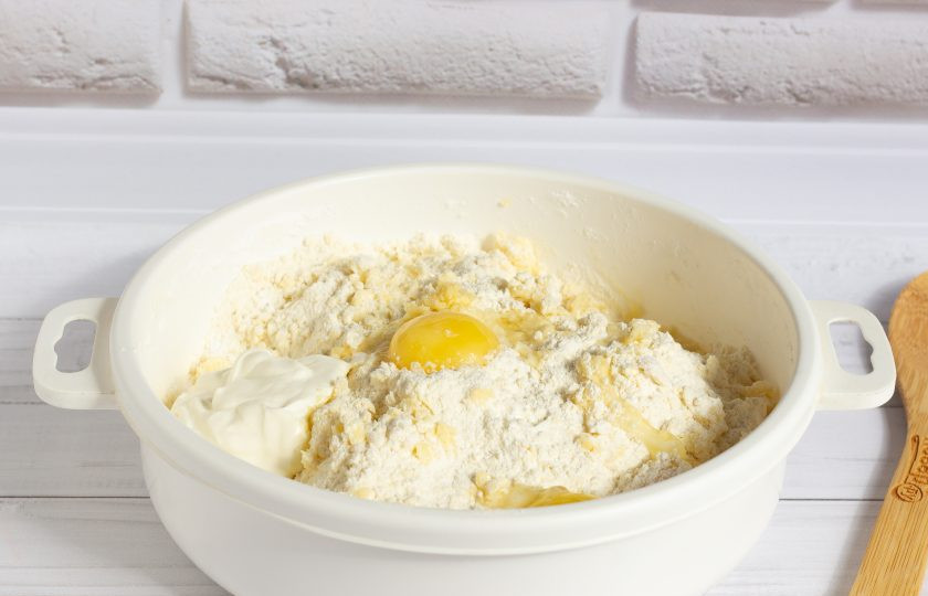 1. Этап. Яблочный пирог по-польски: Порубите масло ножом и разотрите в крошку. Добавьте желтки и йогурт. Замесите мягкое тесто. Если тесто плохо формируется, то добавьте немного белка.