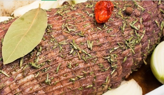 1. Этап. Ростбиф из мраморной говядины: 3. Маринад для такого мяса подходит самый простой: соль, перец, розмарин, лавровый лист, черный перец, чеснок, базилик и даже барбарис. В сочетании все эти травы придадут мясу удивительный и неповторимый аромат и вкус. Натираем говядину, даем ей немного постоять. Её можно поместить в сеточку или перевязать специальными нитями, после чего выложить нарезанный на половинки лук и полить немного соевым соусом с оливковым маслом.