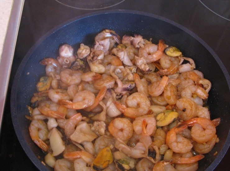 1. Этап. Китайская лапша с морепродуктами: 7. Добавляю к обжаренному чесноку размороженные и промытые морепродукты, перемешиваю и обжариваю в течение 10 минут, периодически помешиваю.