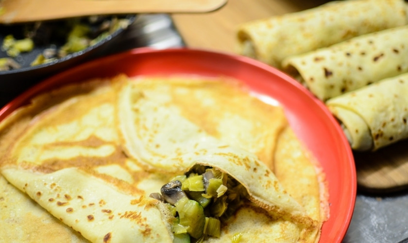 1. Этап. Блинчики с овощной начинкой: Выложите немного тушёных овощей у края блинчика, как на фотографии.