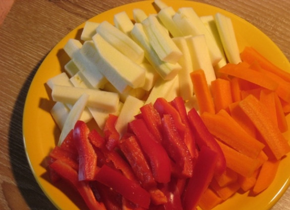 1. Этап. Баранина с овощами в рукаве: Тем временем подготовьте овощи. Кабачок, морковь и перец порежьте крупными брусками. Смешайте их, посолите и добавьте ложку масла.