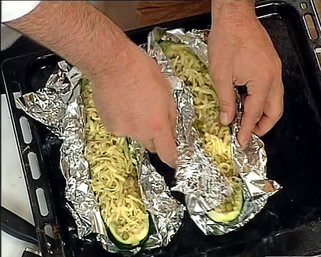 1. Этап. Кабачки с тушенкой: Разложите кабачки на столе. Ложкой закладываем в них начинку со сковородки. Присыпаем тертым сыром. Заматываем все это дело фольгой и ставим в духовку на 15 минут. Температуру выставляем 220 градусов.