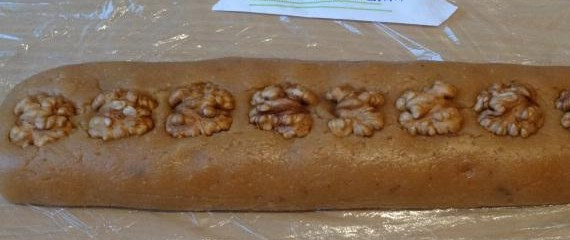 1. Этап. Армянская халва: Сверху выкладываем половинки орехов, слегка вдавливаем их. Заворачиваем халву в плёнку и убираем в холодильник на 3 часа.