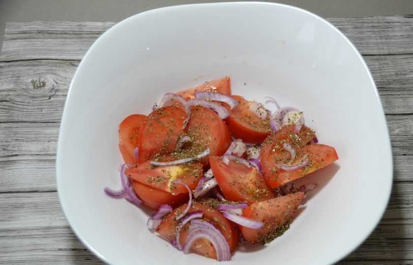 1. Этап. Ялтинский салат: Выложите в салатник лук, помидоры, посыпьте базиликом, посолите, добавьте пару щепоток сахарного песка.