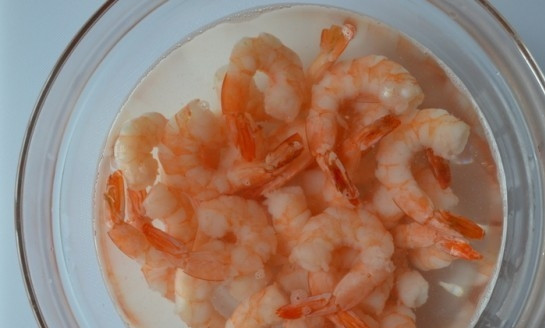 1. Этап. Сырный суп с морепродуктами: Замороженные креветки залейте кипятком, дайте им настояться 4 минуты. Потом откиньте их в дуршлаг. Удалите хвостики, оставив пару целых для крашения. Остальные креветки нарежьте.