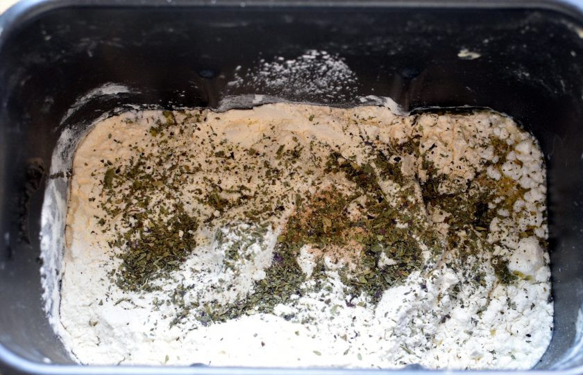 1. Этап. Французский хлеб с ветчиной: Всыпьте просеянную муку, добавьте дрожжи и сухой базилик. Поставьте программу замеса хлеба.