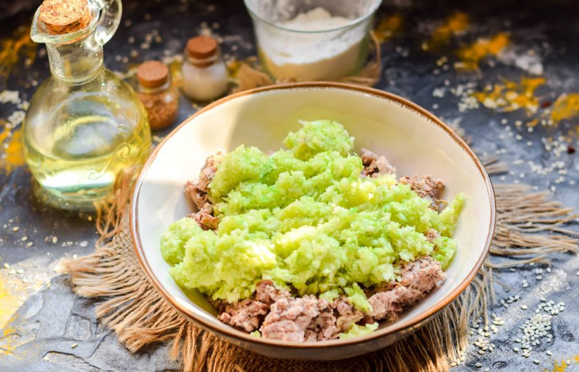 1. Этап. Запеканка из кабачков с фаршем и помидором: Молодой кабачок сполосните и пропустите на мясорубке. Добавьте кабачок в фарш.