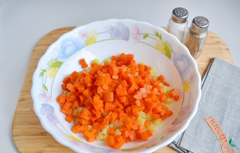 1. Этап. Русский салат Оливье: 3. Очищенную морковь порежьте маленькими кубиками. Положите к картофелю.