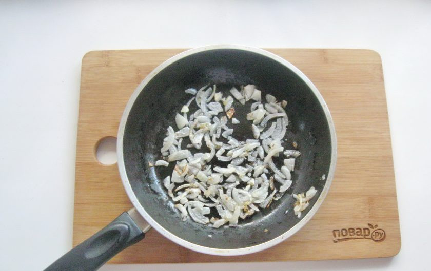 1. Этап. Салат Счастливый Ганс: Репчатый лук очистите и мелко нарежьте. Обжарьте в сковороде на подсолнечном масле.