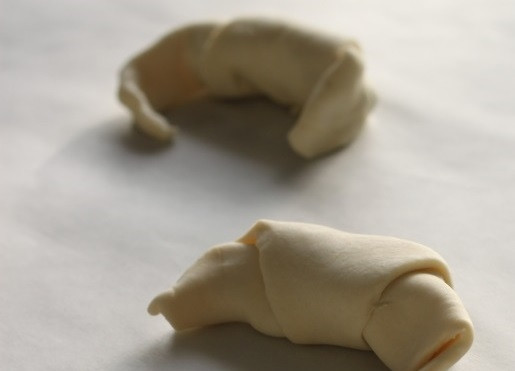 1. Этап. Мини круассаны: 2. Осторожно сверните и выложите на противень, застеленный пергаментом. Чуть сверните круассаны полумесяцем.