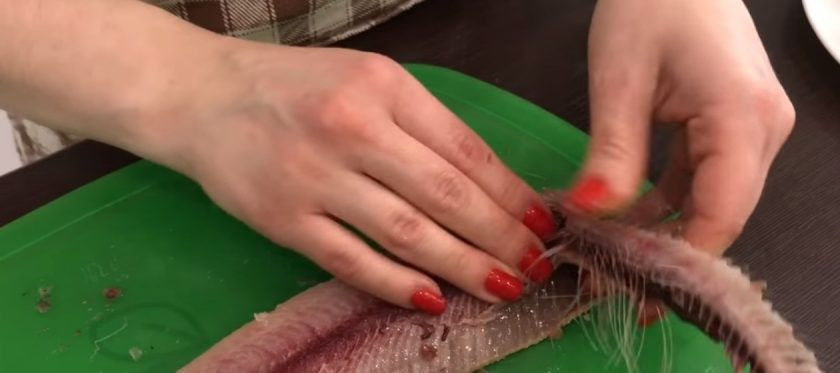 1. Этап. Форшмак из селедки (очень вкусный): 2. Отрежьте голову и хвост. Сделайте разрез снизу рыбы и очистите её от внутренностей. Отрежьте 1 см сельди снизу по всей длине. Затем двумя пальцами пройдитесь по хребту сверху и снизу, как бы отделяя его от тушки, вдавливая его вниз.