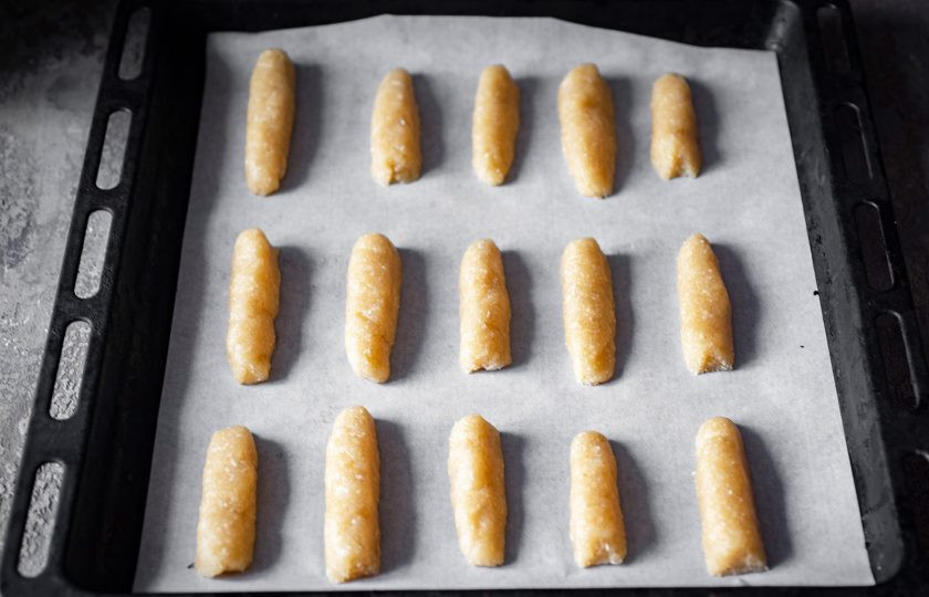 1. Этап. Печенье Арахисовые палочки: Из теста сформируйте заготовки печенья в виде палочек и выложите на противень, застеленный пергаментом для выпекания. Печенье выпекайте 15-20 минут в уже разогретой до 180 градусов духовке.