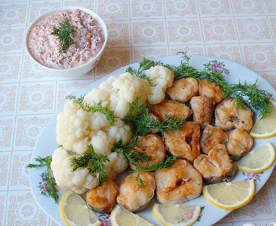 1. Этап. Хек с пряным сметанным соусом: 4. Жареную рыбу выкладываем на блюдо, так же и вареную капусту. Украшаем зеленью и лимоном. Соус подаем отдельно.