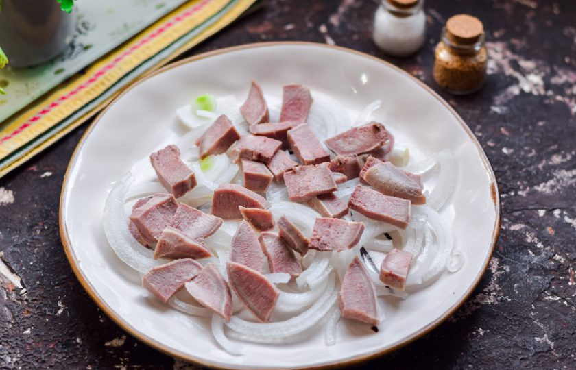 1. Этап. Салат с языком и маринованным луком: Язык сразу после варки отправьте под ледяную воду, после почистите его при помощи ножа. Нарежьте язык кусками или полосками, добавьте к луку.