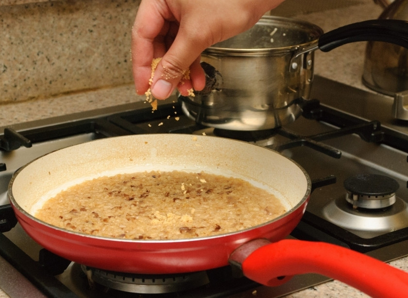 1. Этап. Ризотто вегетарианское: Когда рис набухнет, на это уйдёт около 10 минут, посыпьте его тёртым сыром Пармезан.