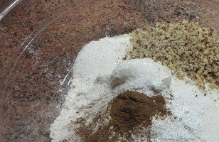 1. Этап. Яблочно-ореховый кекс: Овсяные хлопья измельчаем в кофемолке в муку. В глубокой посуде смешиваем три вида муки, измельченные грецкие орехи, соду пищевую и корицу. Отдельно соду гасить не надо, т. к. в ингредиентах есть лимонный сок.