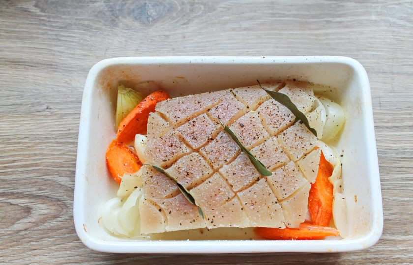 1. Этап. Свинина по-датски: Достаньте форму из духовки и переверните мясо кожей вверх. Все хорошо посолите, поперчите и вставьте в разрезы лавровые листочки.