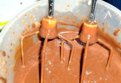 1. Этап. Картошка из печенья: На водяной бане растопите шоколад, предварительно поломав его на кусочки и залив молоком. Вылейте его в чашу от миксера. Добавьте размягченное сливочное масло, взбейте в однородную массу миксером.