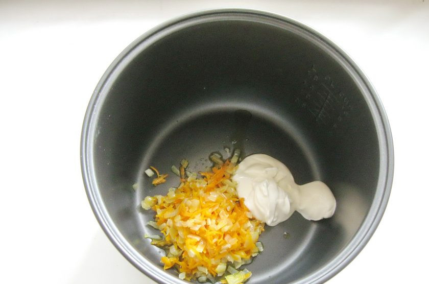 1. Этап. Кабачки фаршированные курицей в мультиварке: В чашу мультиварки выложите вторую часть тушеной моркови с луком и сметану.