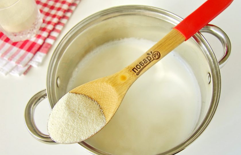 1. Этап. Манные биточки как в детском саду: Как только начнет появляться пенка на поверхности, перемешиваем молоко ложкой и не переставая мешать, всыпаем тонкой струйкой манную крупу.