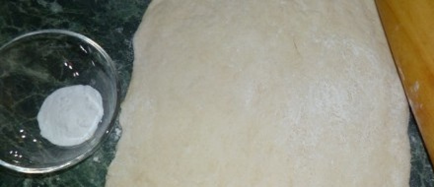 1. Этап. Пирожки из бездрожжевого теста: Затем раскатайте тесто в пласт и присыпьте его 1/3 частью соды по всей поверхности.